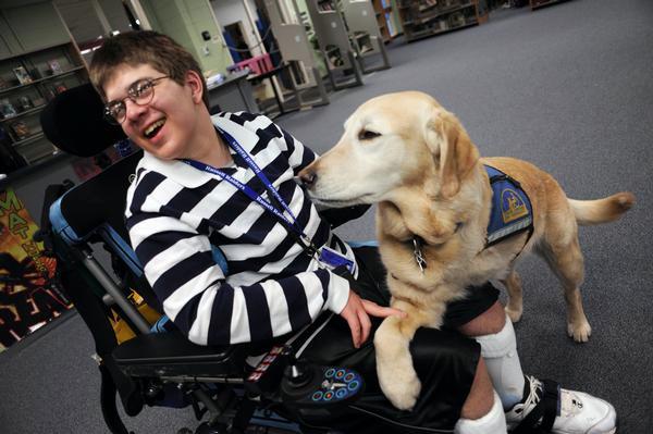 Veren Betzen, 14, pets his service dog Comet after American History class at Russel Middle School. The (The Denver Post, Hyoung Chang)
